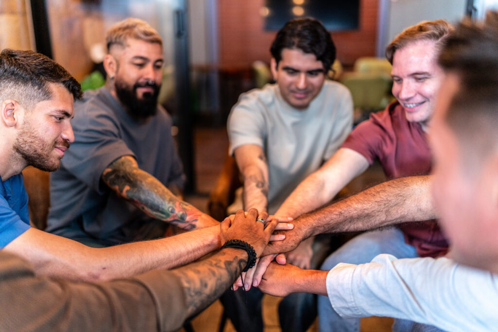 Männer in eine rGruppe legen die Hände aufeinander Solidargemeinschaften